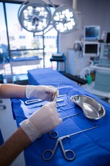 Nurse holding surgical tool in operation theater