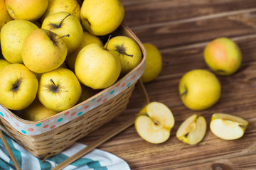Golden apples in a basket on a wooden background - 130651492