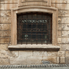 Window of old european shop with forged rusty burglar bars