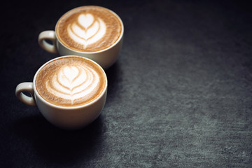 Two cups of coffee on black rustic background - 130652441