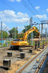 Экскаватор устанавливает сваю для новой платформы железнодорожной станции