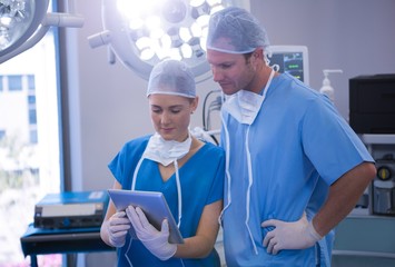 Male and female nurse using digital tablet in operation theater