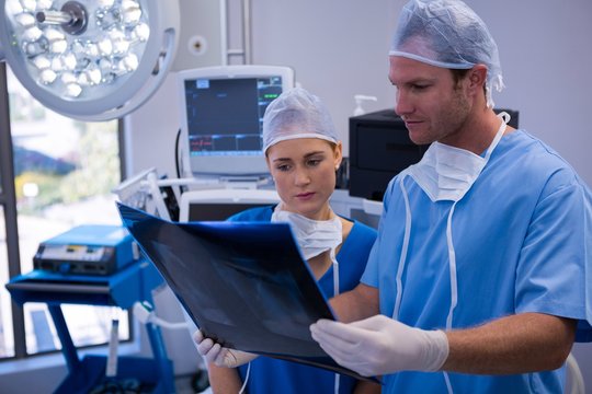 Male and female nurse examining x-ray in operation theater
