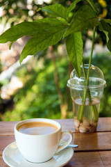 cup of fresh coffee with coffee beans on wooden table