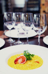 Risotto with shimp on arranged table, toned