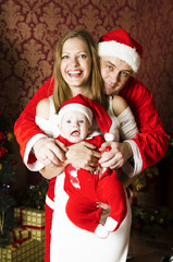 Happy family on Christmas and New Year. Father Mother and baby in Christmas designed home. Santa Close, Baby dwarf and white princess