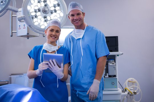 Male and female nurse using digital tablet in operation theater - Powered by Adobe