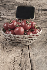 chalkboard on ripe tomatoes on wooden table