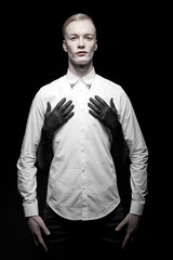 Junger blonder Mann mit roten Lippen vor schwarzem Hintergrund