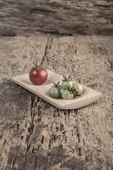 Ripe and unripe tomatoes on wooden table