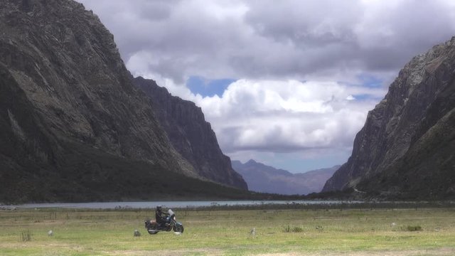 Man on motorcycle adventure passing on a ricky valley of the Huascaran park. 4k