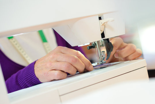 Closeup of woman using sewing machine