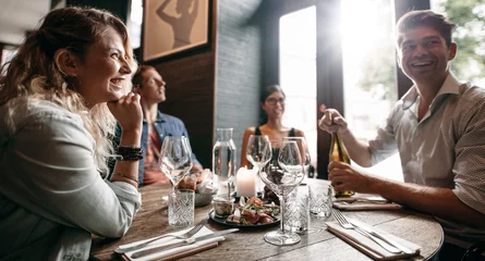 Keuken spatwand met foto Group of friends enjoying an evening meal at a restaurant © Jacob Lund