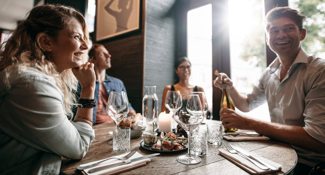 Group Of Friends Enjoying An Evening Meal At A Restaurant