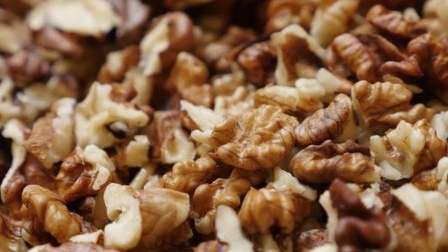 Juglans regia brown pieces shallow DOF 4K 2160p 30fps UltraHD pan footage - Healthy walnut out its shell food pile background 3840X2160 UHD panning video