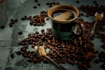 Coffee cup with beans and sugar on vintage metal background, copy space