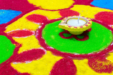 Fototapeta premium clay diya on a colorful rangoli 