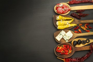 Ingredients for spicy barbecue on the wooden spoon. Dried chillies and spicy peppers filled with cheese. Delicacy suitable for grilled meats. Chillies and cheese. Advertising on spicy delicacies.

