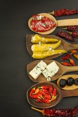 Ingredients for spicy barbecue on the wooden spoon. Dried chillies and spicy peppers filled with cheese. Delicacy suitable for grilled meats. Chillies and cheese. Advertising on spicy delicacies.
