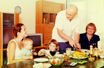 Obraz na płótnie Canvas happy three generations family together over table