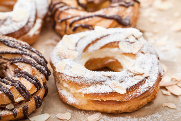 Obraz na płótnie Canvas Chocolate and powdered sugar cream puff rings (choux pastry)