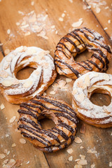Chocolate and powdered sugar cream puff rings (choux pastry)