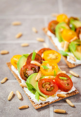 Сrisp bread toast  with cream cheese, fresh avocado, cherry tom