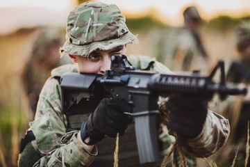 Fototapeta premium Rangers shooting with his weapon, rifle at sunset. War, army