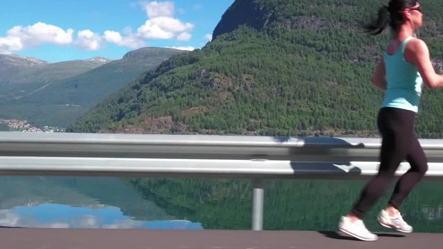 Woman jogging outdoors slow motion. Norwegian fjord.