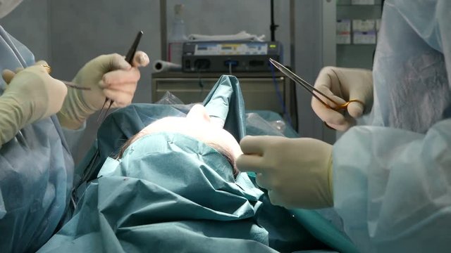 Surgeons stitching up in surgery room during operation.