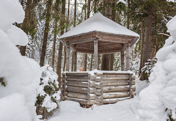 Wooden arbor in snowy forest