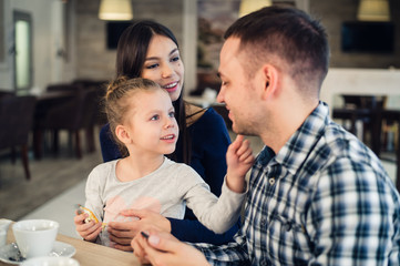 Family Enjoying tea In Cafe Together