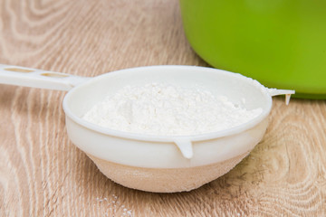 Sieve with the flour on the table in the kitchen. Healthy eating and lifestyle.