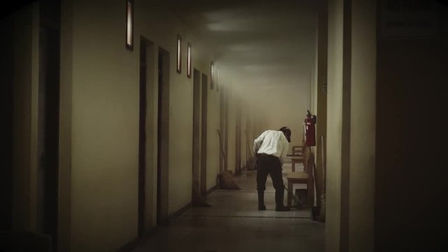 Hispanic janitor cleaning the hallway with a mop, black and white. Slow motion