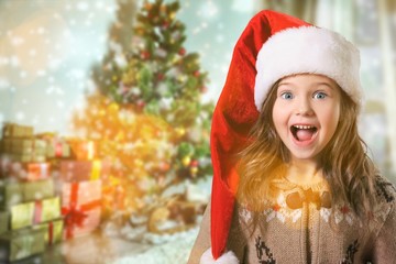 Happy child girl in a christmas hat.