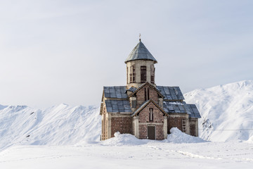 Fototapeta na wymiar Winter in Greater Caucasus Mountains. Georgia (country). Gudauri ski resort. Georgian orthodox church.