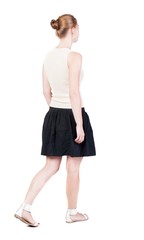 back view of walking  woman in dress. beautiful blonde girl in m