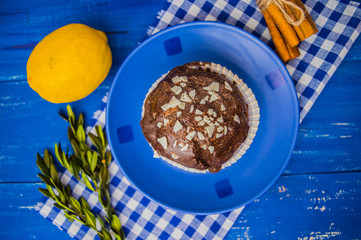 Black Chocolate muffin on a blue wooden background. Top view. Close-up