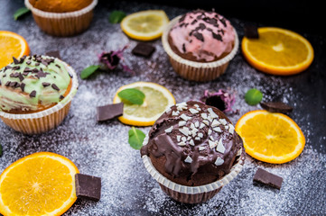 Cupcakes with fruit and powdered sugar on a dark background. Top view. Close-up