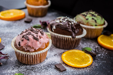 Cupcakes with fruit and powdered sugar on a dark background. Top view. Close-up