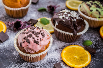 Cupcakes with fruit and powdered sugar on a dark background. Top view. Close-up