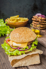 Great Hamburger and french fries on a wooden table in rustic style. Close-up