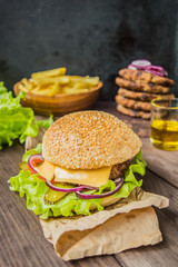 Great Hamburger and french fries on a wooden table in rustic style. Close-up