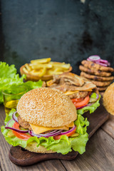Great Hamburger and french fries on a wooden table in rustic style. Close-up
