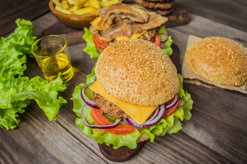 Great Hamburger and french fries on a wooden table in rustic style. Close-up