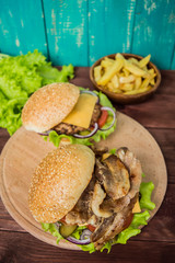 Great Hamburger and french fries on a wooden table in rustic style