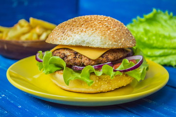 Great Hamburger and french fries on a wooden table in rustic style. Top view. Close-up