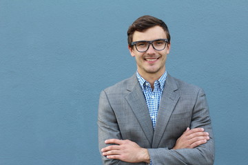 Young handsome man with great smile wearing fashion eyeglasses against neutral blue background with lots of copy space