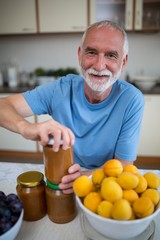 Senior man opening bottle of jam