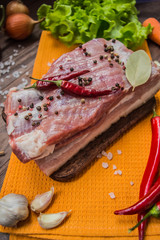 Raw bacon with herbs on a wooden table. Top view. Close-up